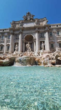 the building has many statues on it and is next to a body of water in front of it