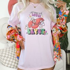 a woman with white hair wearing a pink t - shirt that says i just want to be cute