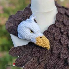 a crocheted bird scarf on a mannequin head with an eagle's beak