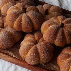 some sugared buns are on a wooden tray