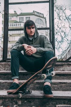 a young man sitting on the steps with his skateboard