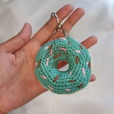 a crocheted doughnut keychain in the palm of someone's hand