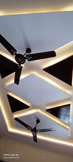 the ceiling fan is lit up and has black blades hanging from it's sides