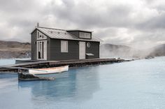 a small house sitting on top of a body of water next to a boat dock