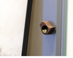 a close up of a door handle with a light on it's side and a wall in the background