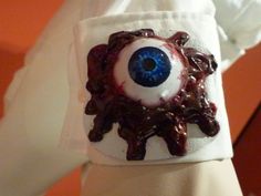 someone is wearing an evil eye on their arm with chocolate dripping from the inside out