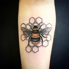 a tattoo on the arm of a person with a bee and honeycombs behind it