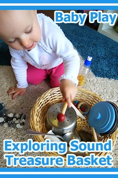 a baby playing with a toy in a basket on the floor next to other toys