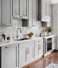 a kitchen with gray cabinets and white counter tops