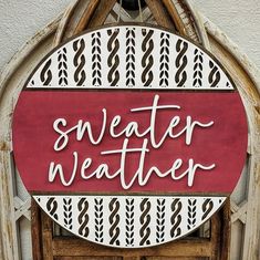 a sign that reads, sweater weather on the side of a building with an arched window