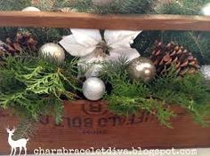 a wooden box filled with ornaments and pine cones