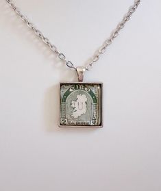 This pretty necklace is made from a genuine 1940s Irish postage stamp.  I love the detailed design of the stamp  . It makes a special gift for anyone who loves Ireland!  The antiqued silver-plated brass pendant measures about 13/16" x 13/16". A domed glass tile protects and enhances the vintage stamp's design. Please choose  your chain length above. Remove before contact with water. Each item comes lovingly wrapped and ready for gift-giving. Antique Stamped Necklace Gift, Rectangular Vintage Charm Necklace As Gift, Rectangular Vintage Charm Necklace For Gift, Rectangular Necklace With Vintage Charm For Gift, Retro Engraved Necklaces For Gifts, Antique Rectangular Necklaces For Gifts, Antique Rectangular Necklace For Gift, Green Stamped Jewelry As Gift, Green Stamped Jewelry For Gifts