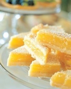 small pieces of fruit on a glass plate with powdered sugar and berries in the background