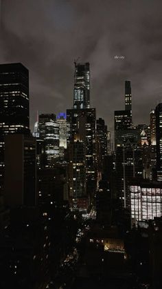 the city skyline is lit up at night, with skyscrapers in the foreground