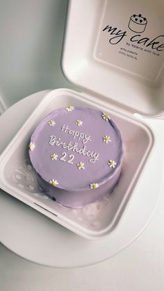 a purple birthday cake in a white container