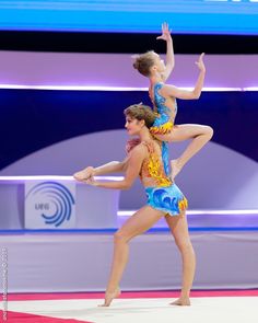 two people are doing acrobatic tricks on the floor