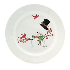 a white plate with red birds and a black hat on it's rim is shown