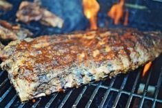 steaks cooking on the grill with flames coming out of it's back end