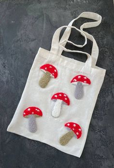 a tote bag with mushrooms on it sitting on top of a black countertop