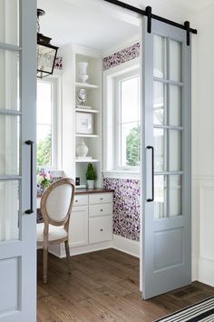 an open door leading to a dining room with white walls and wood flooring on the other side