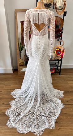 the back of a white wedding dress, with long sleeves and fringes on it