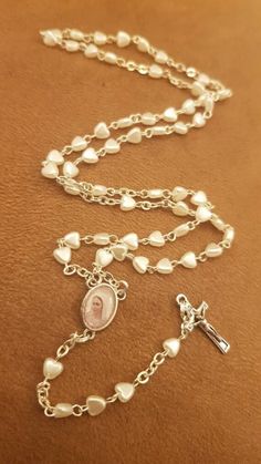 Handmade rosary necklace. Made with silver metal wire and 5 mm white hearts pearls. This rosary is perfect gift for many occasions, birthday, easter, confirmation, wedding... Can be personalizade. On this rosary you can put name. Rosary is 17 inch ( 44 cm ) long. Can be ordered in large numbers and be used as a gift in weddings or other occasions - WITH DISCOUNT! Perfect gift for first communion or confirmation for boy or a girl. **GIFT** Message card of Our Lady from Medjugorje. For more great Personalized Silver Rosary For First Communion, Silver Pearl Rosary For First Communion, Personalized Silver Rosary For Confirmation, White Miraculous Medal Necklace For Wedding, Our Lady Of Medjugorje, Olive Wood Cross, Personalized Rosary, Pearl Rosary, First Communion Gifts