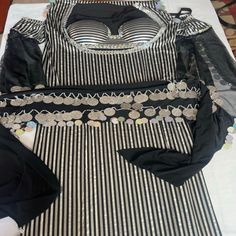 several pieces of clothing sitting on top of a table with white and black striped cloth