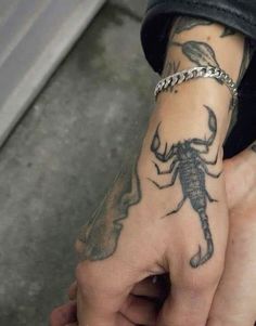 a hand with a scorpion tattoo on it