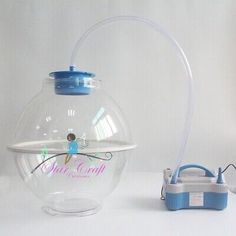 a clear glass fish bowl next to a blue and white lunch box with a handle