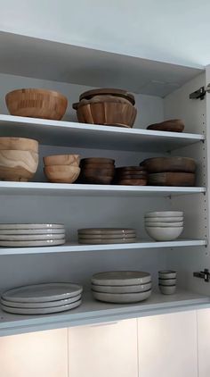 the shelves are filled with dishes and bowls