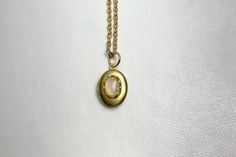 This sweet, small, OVAL brass locket has a natural Ethiopian Opal cabochon set on the front.  The cabochon sits in a brass lace edged setting. It hangs on a 16" gold-plated stainless-steel chain necklace.  The locket is approximately 11x16mm.  The cabochon is 5x7mm.  Arrives in an eco-friendly jewelry box, ready for gifting. MORE lockets in the shop! FREE SHIPPING! THANK YOU FOR VISITING! Handmade Gold Locket Necklace For Memorial, Oval Cabochon Brass Necklace, Handmade Oval Brass Locket Necklace, Adjustable Gold Cabochon Necklace, Stainless Steel Chain Necklace, Eco Friendly Jewelry, Lace Edging, Stainless Steel Chain, Antique Style