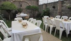 an outdoor dining area with tables and chairs set up for a formal function in the garden