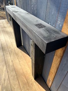 a wooden bench sitting on top of a wooden floor next to a wall with wood planks