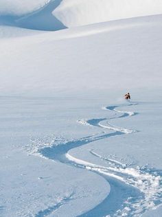 a man riding skis down the side of a snow covered slope