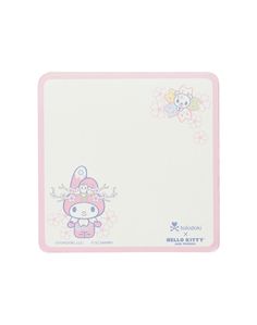 a hello kitty mouse pad sitting on top of a white tablecloth with pink trim