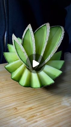 a green flower sitting on top of a wooden table