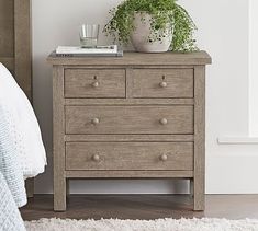 a bed room with a neatly made bed and a wooden dresser