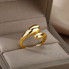 a gold ring sitting in a box on top of a table