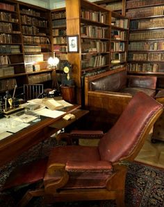 an old library with leather chairs and bookshelves