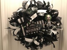 a black and white wreath with a creepy doll on it