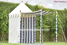 a white and blue striped tent sitting in the grass