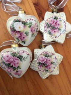 four heart shaped ornaments with pink flowers on them