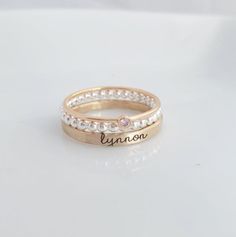 Mother's Day Gift | -the Isabelle- Personalized stackable ring set, engraved with a name, date, or special word.  Metal: .925 sterling silver, and 14k gold filled Dimensions: name ring is 2mm tall on average, but our rings are handmade so variations will occur. Birthstone is 2mm on a 1mm band. Font: lowercase typewriter Unsure what size you need? We highly recommend using our ring sizer for an accurate fit. Some people find that sizing up when stacking 3 or more rings is more comfortable. https: Custom Name Adjustable Stackable Rings, Adjustable White Gold Stackable Rings With Birthstone, Adjustable Stackable Rings With Custom Name, Adjustable Stackable Jewelry For Anniversary, Dainty Personalized Round Band Jewelry, Custom Name Gold Stackable Rings In Sterling Silver, Personalized Rose Gold Stackable Rings, Personalized Rose Gold Stackable Rings With Round Band, Adjustable White Engraved Ring For Promise