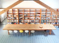 a wooden table sitting in front of a bookshelf filled with lots of books