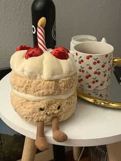 a cake sitting on top of a table next to a cup