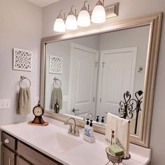 a bathroom sink with a mirror and lights above it