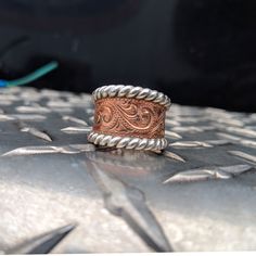 This is a beautiful tapered copper hand-engraved ring with a sterling silver "rope" edge, hand-made with love in Eminence, Missouri by Western designer and engraver Ryan Liggett. This lovely Western ring features a wriggle line/scroll design. This ring is our classic wide tapered style and is around 18 MM in the front and tapers to 9 MM in the back (though individual rings may vary!). We make each piece by hand, one at a time, for every order. Because of this, your final piece may vary slightly Punchy Jewelry, Western Engagement Rings, Cowgirl Ring, Western Ring, Western Rings, Country Clothes, Cowgirl Accessories, Western Clothes, Leather Jewels