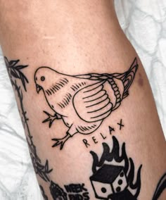 a close up of a person's leg with a bird tattoo on the side