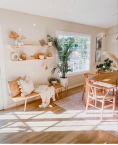 a dining room table and chairs in front of a large window with potted plants