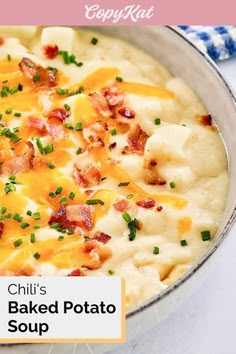 a close up of a bowl of food with cheese and bacon on top, sitting on a table